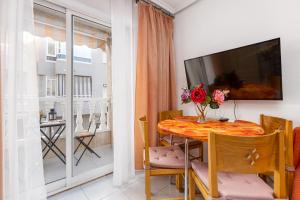 een kleine eetkamer met een tafel en een televisie bij Apartment Studio Relax Almudena in Torrevieja