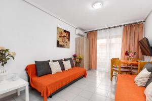 een woonkamer met een oranje bank en een tafel bij Apartment Studio Relax Almudena in Torrevieja