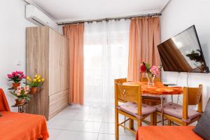 een eetkamer met een tafel en een televisie bij Apartment Studio Relax Almudena in Torrevieja