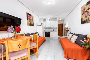 een woonkamer met een tafel en een bank bij Apartment Studio Relax Almudena in Torrevieja