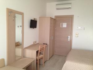 Schlafzimmer mit einem Schreibtisch, einem Bett und einem Spiegel in der Unterkunft Hotel Incanto in Peschici
