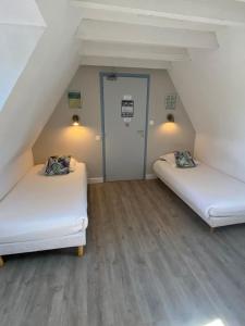 a attic room with two beds and a door at Amadour Hôtel in Rocamadour