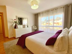 a bedroom with a large bed and a window at Jardins da Parede 211 in Parede