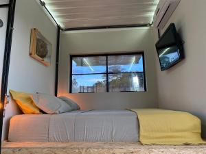a bedroom with a bed and a window at Hospedaria BOCA DO MATO - CONTAINER in Mambaí