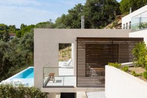 a house on a hill with a pool at Skiathos Symbol Villas in Achladies