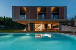 a house with a swimming pool in front of it at ARGENTO RESIDENCE in Zagvozd