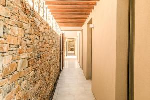 a hallway with a stone wall at Skiathos Symbol Villas in Achladies