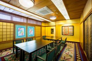 comedor con mesas, sillas y vidrieras en Hotel Sekifu, en Fuefuki