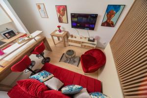 a living room with a red couch and a tv at Soho City MK LUX Apartment in Bar