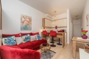 a living room with a red couch and a kitchen at Soho City MK LUX Apartment in Bar