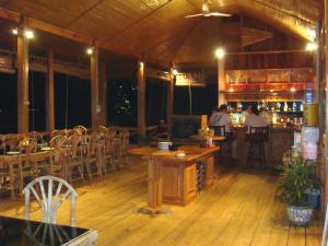 ein Restaurant mit Tischen und Stühlen und einer Bar in der Unterkunft Bunaken Divers Sea Breeze Resort in Bunaken