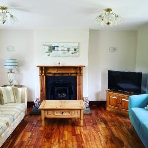 a living room with a couch and a fireplace at Delightful stone barn, with superb views, Ramsgill in Pateley Bridge