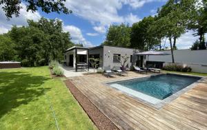 a backyard with a swimming pool and a house at Le Clos des Bleynoux in Saint-Étienne-de-Fontbellon