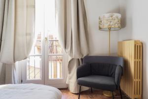 a bedroom with a chair and a window at Mila Apartments Magenta in Milan