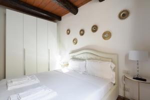 una camera da letto con un letto bianco e specchi sul muro di Mila Apartments Magenta a Milano