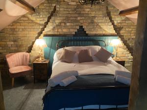 Un dormitorio con una cama grande y una silla. en Farndale House-Hot tub, en Amble