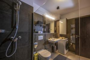 a bathroom with a shower and a toilet and a sink at Sybill Suite in Keszthely +38 photos