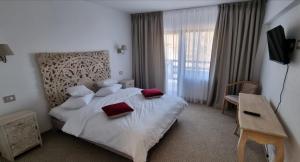 a hotel room with a bed with red pillows on it at Vale Humor Residence in Mănăstirea Humorului +80 photos