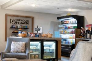 a room with a counter with an open refrigerator at Candlewood Suites East Lansing, an IHG Hotel in Lansing