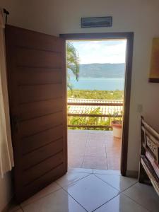 una puerta que da a un balcón con vistas al océano en Chale Por do Sol, en Ilhabela