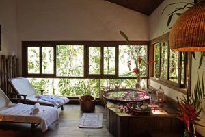 a living room with a large window and a tub at Pousada e SPA Bromelias in Paraty