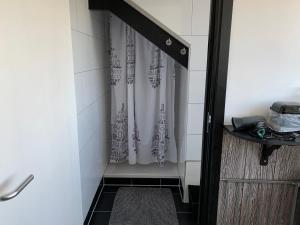 einen Duschvorhang in einem kleinen Bad mit Dusche in der Unterkunft Bed&Breakfast Jonker in Burgh Haamstede