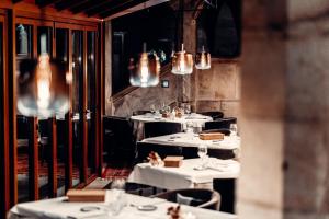 a restaurant with white tables and chairs and chandeliers at Romantik Hotel Schloss Hohenstein in Ahorn
