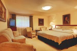 une chambre d'hôtel avec un lit et un canapé dans l'établissement Dworek Genny, à Polanica-Zdrój