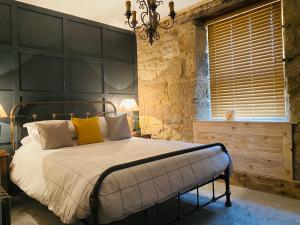 a bedroom with a bed with a black headboard at The Wynd Cottage in Amble