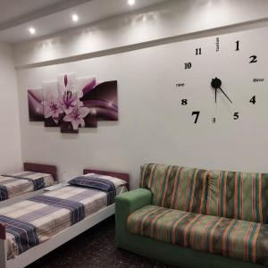 um quarto com duas camas e um relógio na parede em ORIZZONTE SUL MARE em Savona