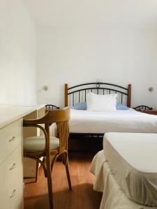 Blu Inn في بونتا دل إستي: غرفة نوم مع سرير ومكتب ومكتب