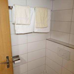 baño con toallas blancas colgadas en la pared en WHITE HOME IN AESCHI BEI SPIEZ en Aeschi bei Spiez