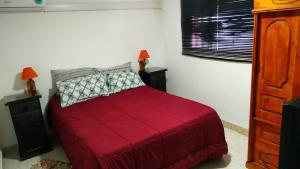 een slaapkamer met een rood bed en 2 nachtkastjes bij Perlas del Mar in Puerto Madryn