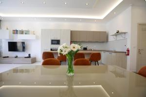 3-bedroom Apartment with views in Iz-Zebbug, Gozo في Żebbuġ: إناء من الزهور على طاولة زجاجية في مطبخ
