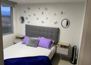 a bedroom with a bed with butterflies on the wall at Espectacular Apartamento VIP - 2 Hab. Ricaurte in Ricaurte +47 photos