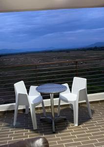 a table and four white chairs on a roof at Espectacular Apartamento VIP - 2 Hab. Ricaurte in Ricaurte