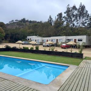 una piscina frente a un parque de caravanas en cabañas laguna de zapallar maitencillo en Zapallar