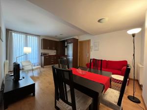 Casa Damian del Baile Apartamentos في بيناسكي: غرفة معيشة مع أريكة حمراء وطاولة