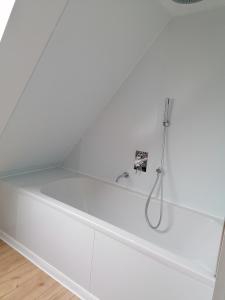 a white bath tub with a shower in a bathroom at Apartment Home 3 in Schwabach