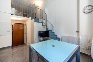 a room with a blue table and a staircase at Esclusivo Loft In Porta Romana, a 250m dalla Bocconi in Milan