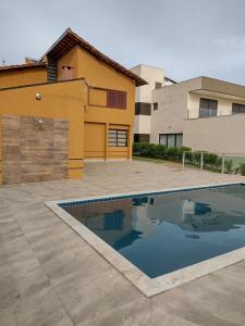 a swimming pool in front of a house at Residência Simone em Escarpas do Lago in Capitólio