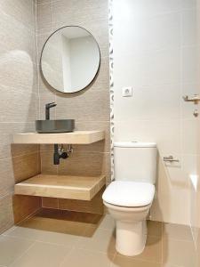 uma casa de banho com um WC branco e um espelho. em Apartamento Casa Chloe em Benasque