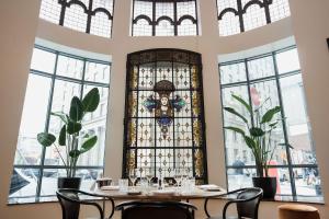 a room with tables and chairs and a stained glass window at Hôtel Birks Montréal in Montreal