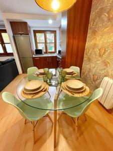 comedor con mesa de cristal y sillas en Apartamento Casa Chloe en Benasque