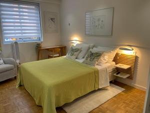 sypialnia z dużym łóżkiem i żółtym kocem w obiekcie Le Copacabana Riviera w Nicei