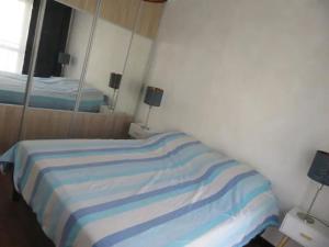 Un dormitorio con una cama con rayas azules y blancas. en Appartement T3, en Rennes