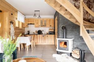 a kitchen with a wood stove in a room at Domek Chatka Góralki in Poronin