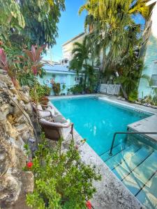 a swimming pool with a chair and palm trees at The Casablanca Hotel in Key West