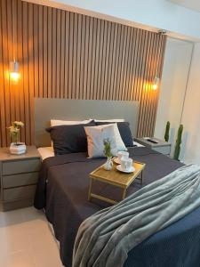 Un dormitorio con una cama con una mesa. en Loft completo e refinado, en Ribeirão Preto