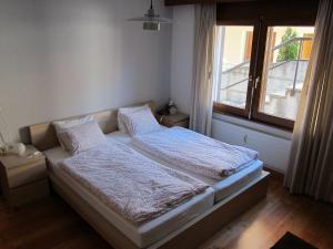 1 dormitorio con 2 camas y ventana en Apartment Lauber, Haus Wichje A, Zermatt, en Zermatt
